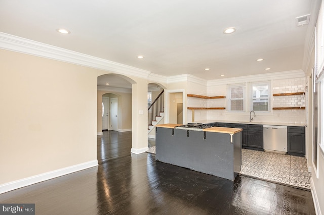 kitchen featuring dishwasher, sink, a kitchen breakfast bar, butcher block countertops, and crown molding