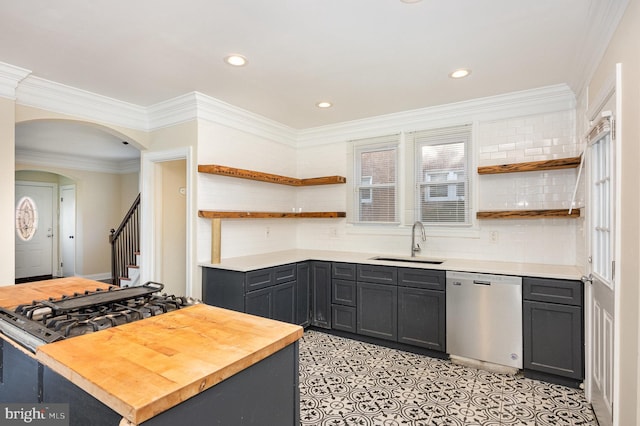 kitchen featuring butcher block countertops, dishwasher, ornamental molding, and sink