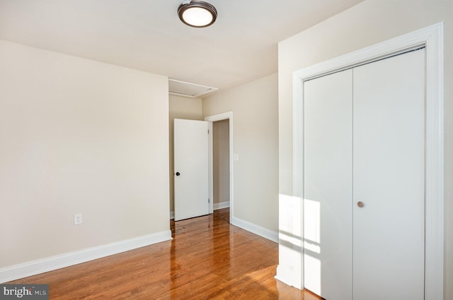 unfurnished bedroom featuring a closet and hardwood / wood-style floors