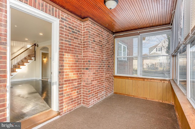 unfurnished sunroom featuring wood ceiling