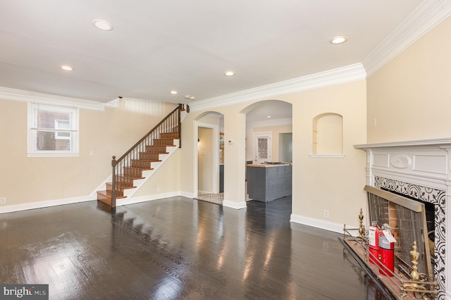 unfurnished living room with a high end fireplace, dark hardwood / wood-style floors, and crown molding