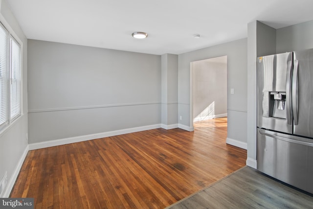 interior space featuring stainless steel fridge, dark wood-type flooring, and a wealth of natural light