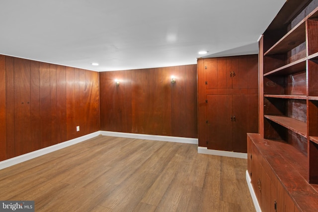 empty room with hardwood / wood-style floors and wooden walls