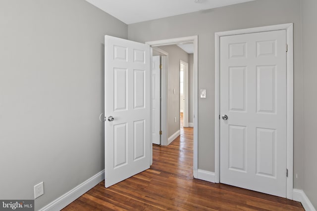 unfurnished bedroom with dark hardwood / wood-style flooring