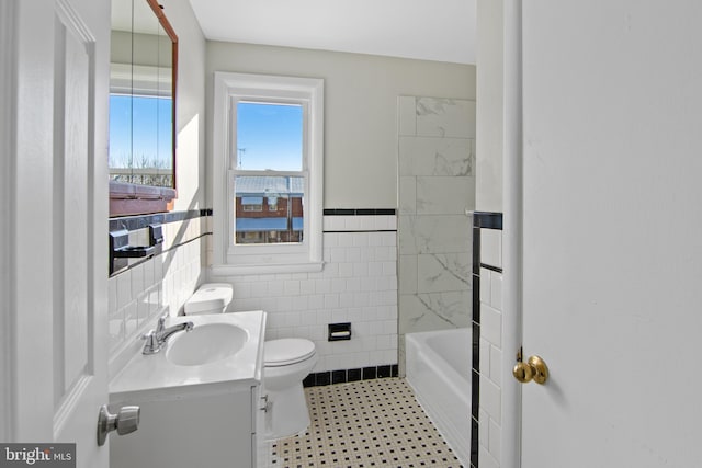 full bathroom featuring shower with separate bathtub, vanity, toilet, and tile walls