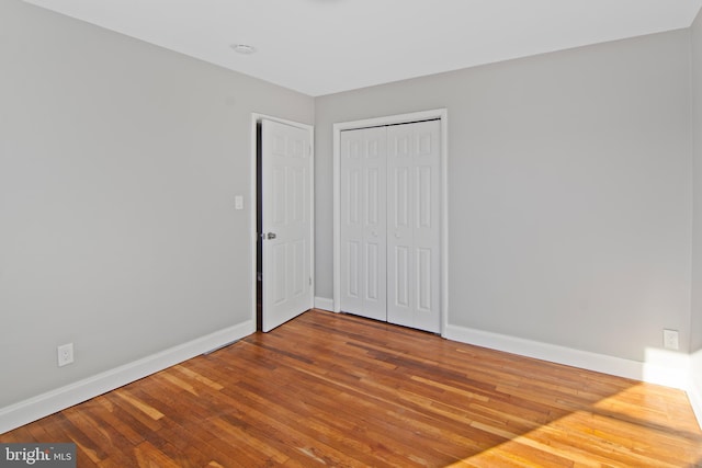 unfurnished bedroom with wood-type flooring and a closet