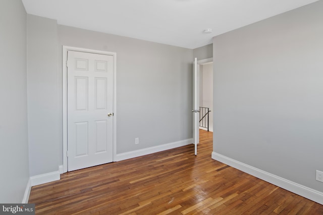 unfurnished bedroom with dark wood-type flooring