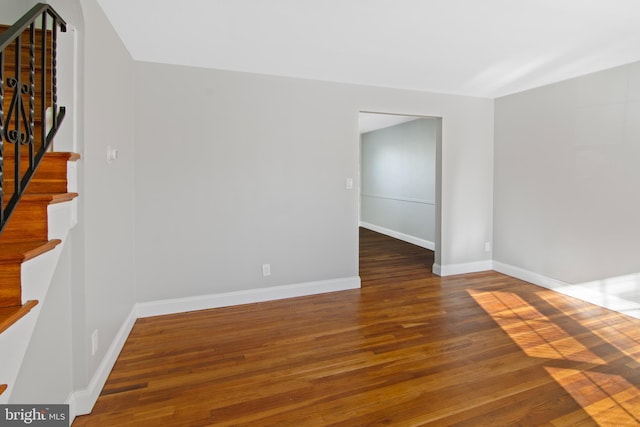 unfurnished room with dark wood-type flooring