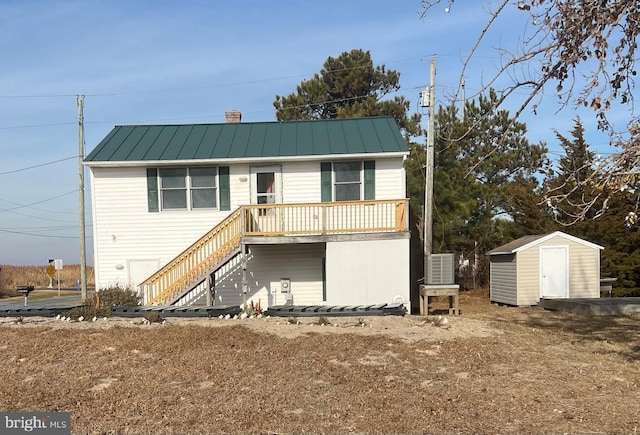 rear view of property with a storage unit