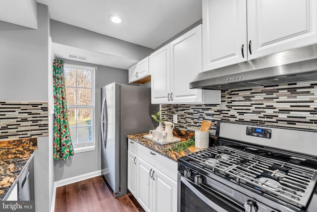 kitchen featuring white cabinets, dark hardwood / wood-style floors, stainless steel appliances, and dark stone counters