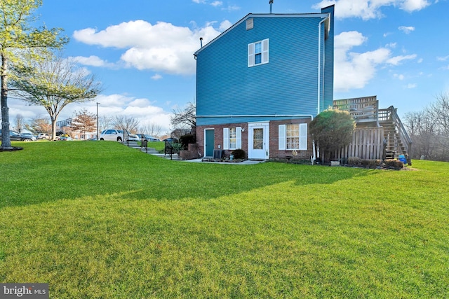 back of property featuring a lawn and central AC