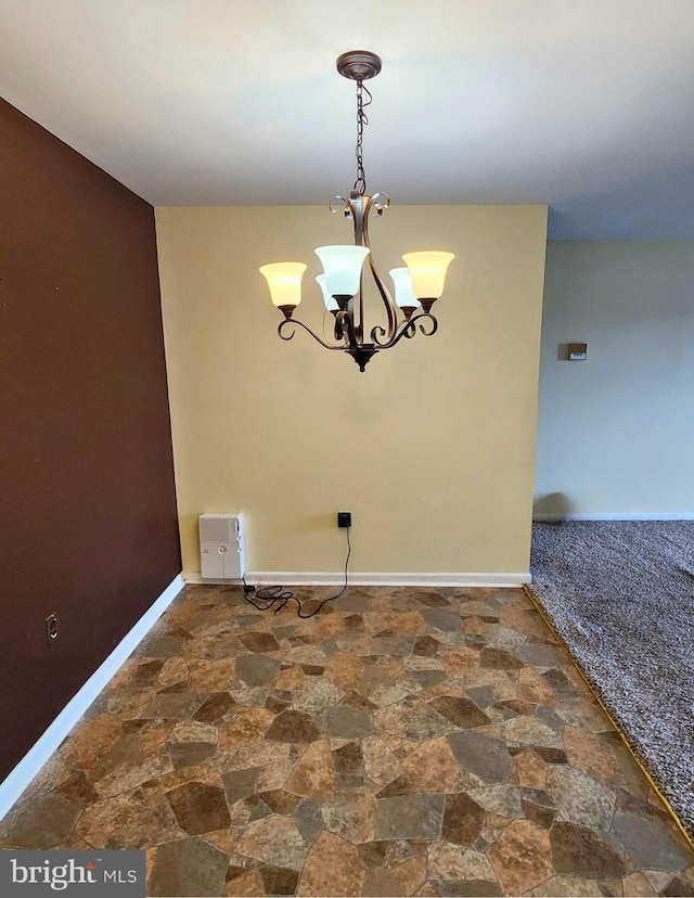 unfurnished dining area featuring a chandelier