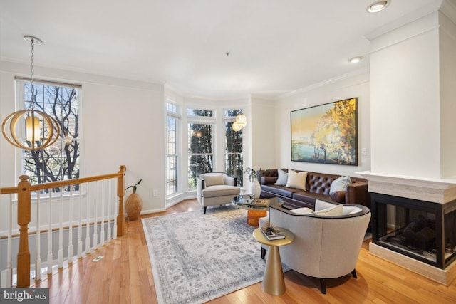 living room with ornamental molding, light hardwood / wood-style floors, and plenty of natural light