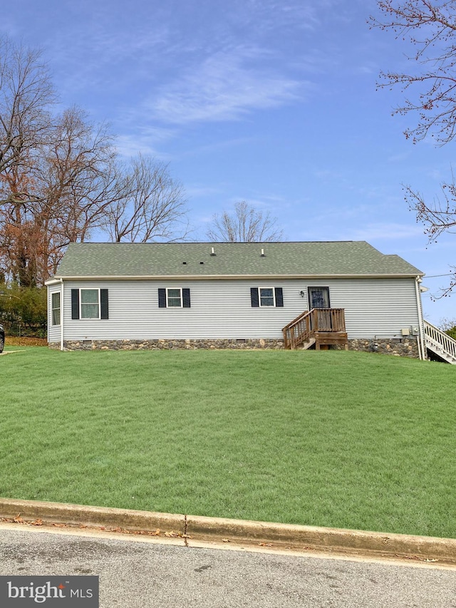 rear view of house featuring a wooden deck and a yard