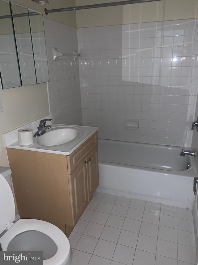 full bathroom featuring tile patterned flooring, vanity, tiled shower / bath combo, and toilet