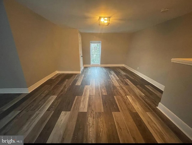 unfurnished room featuring dark wood-type flooring