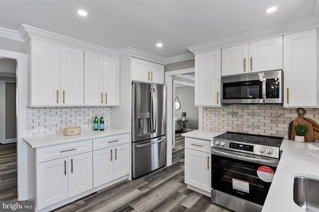 kitchen featuring light stone countertops, stainless steel appliances, backsplash, crown molding, and white cabinets