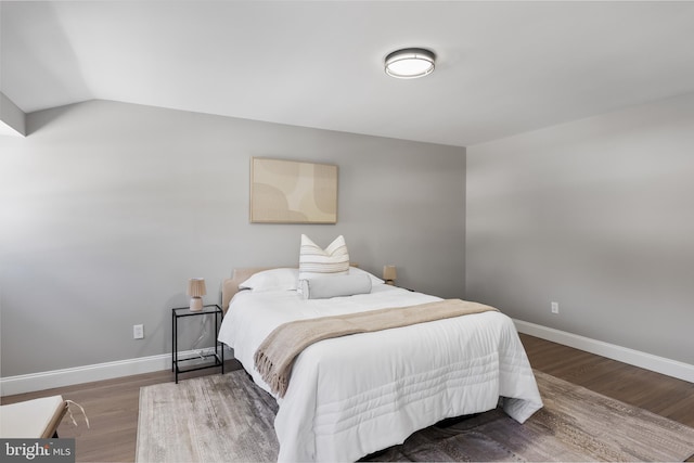 bedroom with hardwood / wood-style flooring and lofted ceiling