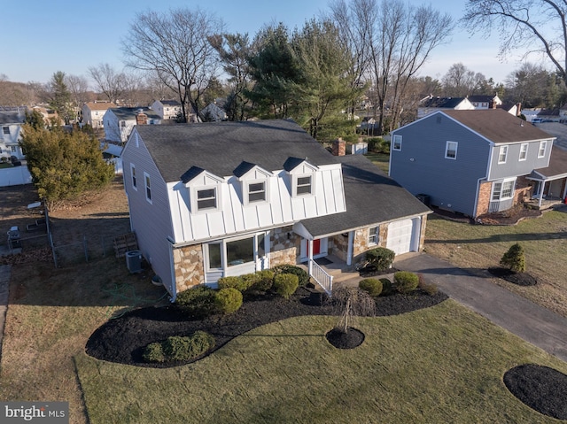 view of front of house with central AC, a front lawn, and a garage