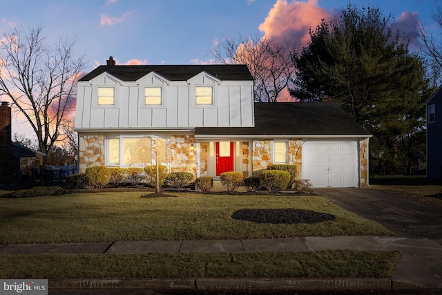 new england style home featuring a yard and a garage