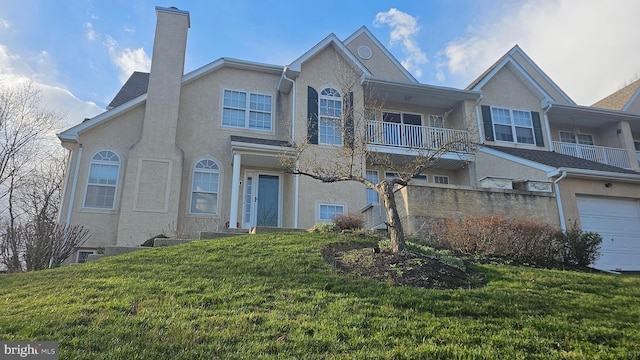 multi unit property with a balcony, a front yard, and a garage