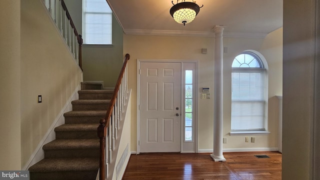 foyer with decorative columns, dark hardwood / wood-style floors, and ornamental molding