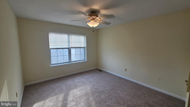 carpeted spare room featuring ceiling fan