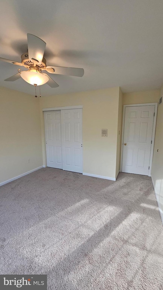 unfurnished bedroom with carpet floors, a closet, and ceiling fan