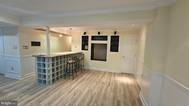 bar with wood-type flooring, pendant lighting, and ornamental molding