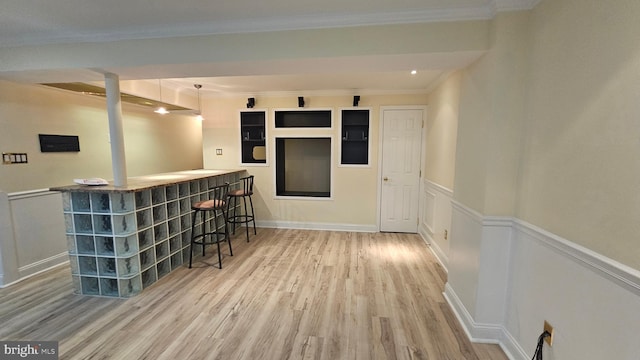 bar featuring pendant lighting, wood-type flooring, and ornamental molding