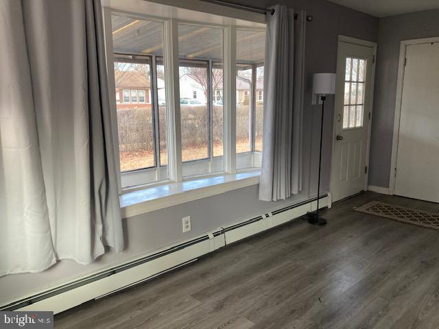 interior space with a baseboard radiator and dark hardwood / wood-style floors