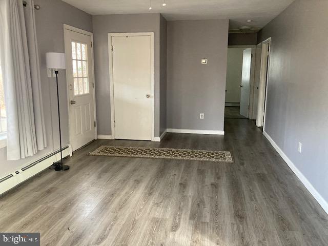 foyer featuring baseboard heating and dark wood-type flooring