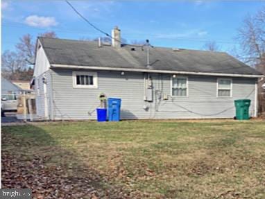 rear view of house featuring a lawn