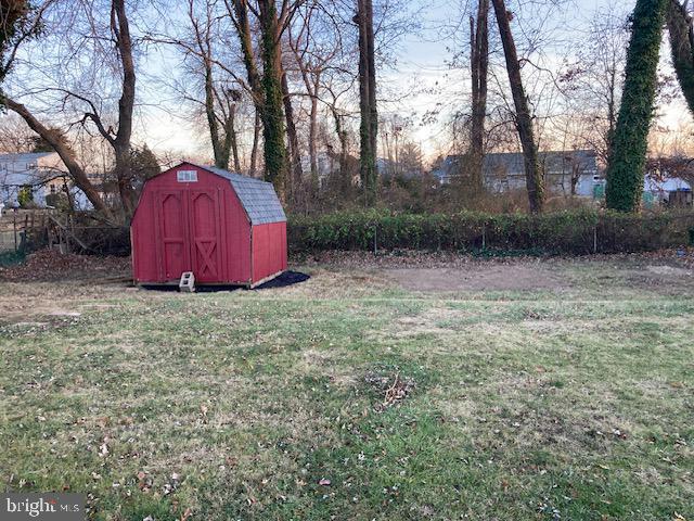 yard at dusk featuring a storage unit