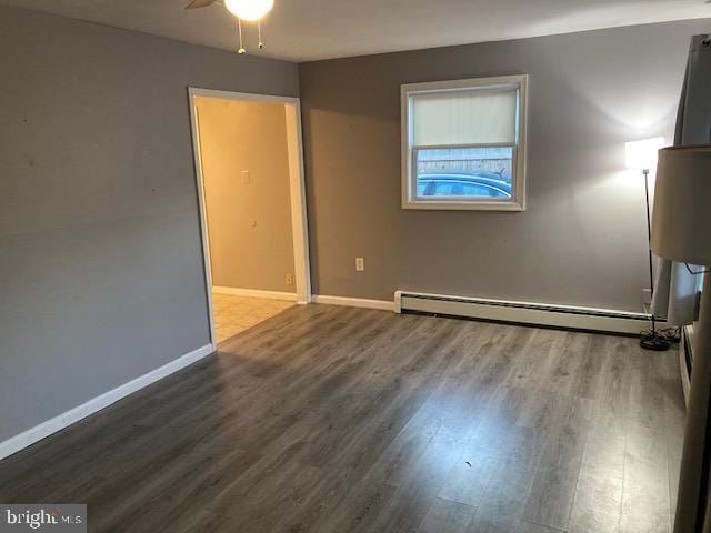 empty room with hardwood / wood-style floors, ceiling fan, and baseboard heating