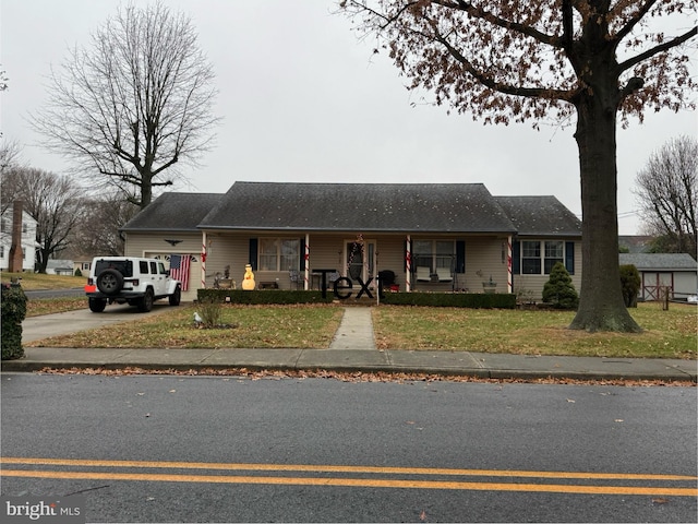 single story home featuring covered porch and a front yard