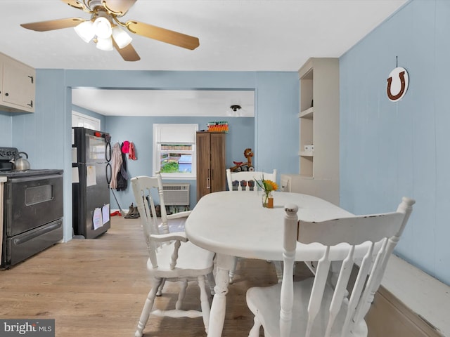 dining area with ceiling fan, cooling unit, and light wood-type flooring