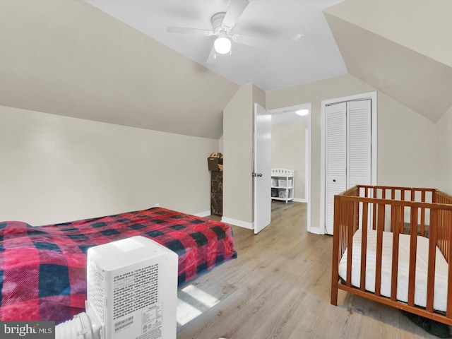 bedroom with light wood-type flooring, a closet, ceiling fan, and lofted ceiling