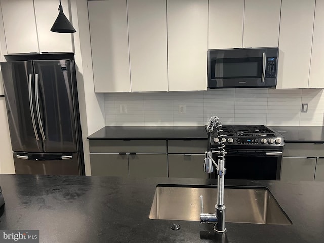 kitchen with sink, stainless steel appliances, backsplash, and white cabinets