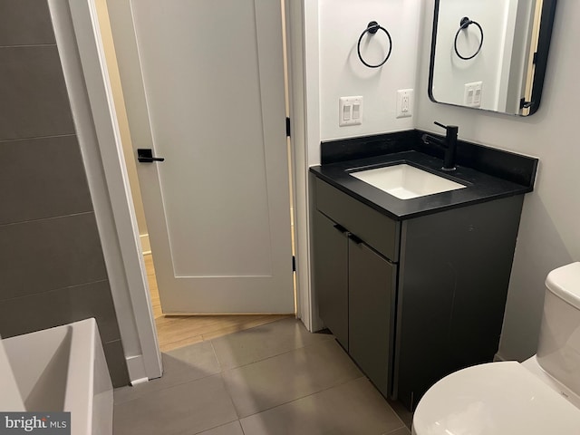 bathroom with tile patterned flooring, vanity, and toilet