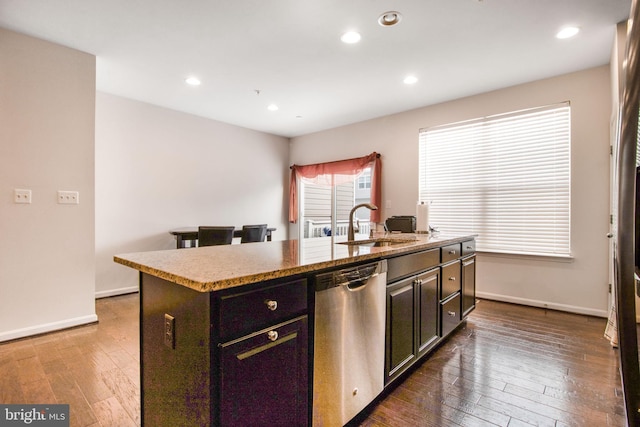 kitchen featuring dishwasher, dark hardwood / wood-style flooring, sink, and an island with sink