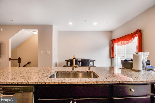 kitchen featuring light stone counters, sink, and stainless steel dishwasher