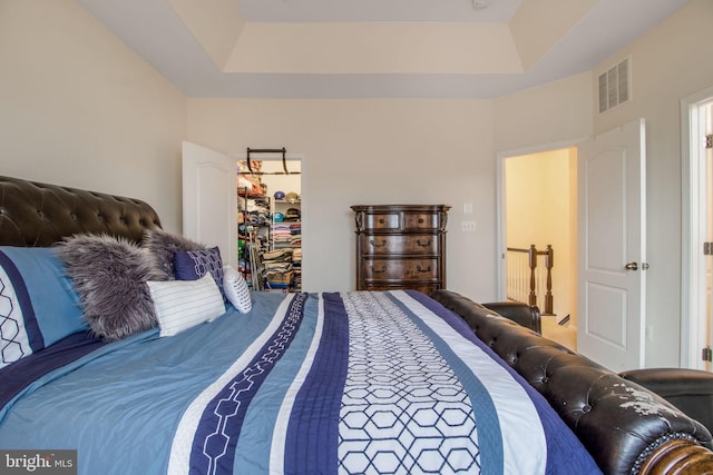 bedroom featuring a tray ceiling and a closet