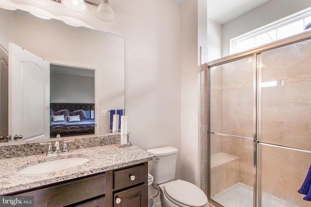 bathroom with vanity, toilet, and a shower with door