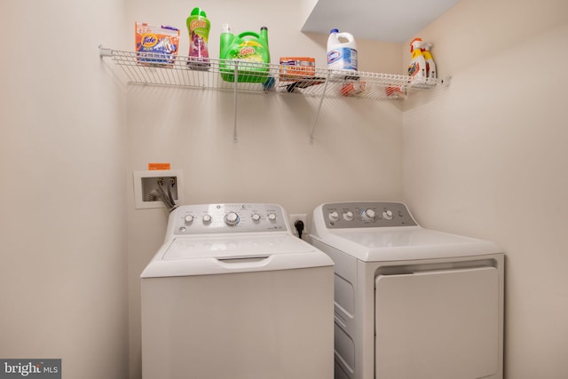 clothes washing area with washing machine and dryer