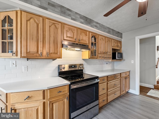 kitchen with ceiling fan, stainless steel appliances, tasteful backsplash, light hardwood / wood-style floors, and a textured ceiling