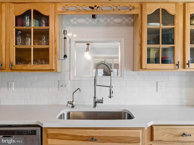 kitchen featuring dishwasher, decorative backsplash, and sink