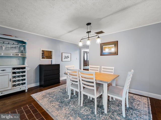 dining space with dark wood-type flooring and a textured ceiling