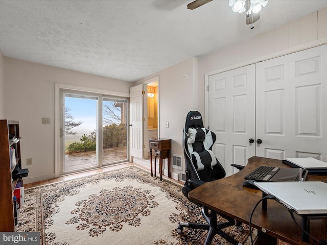 home office featuring a textured ceiling and ceiling fan