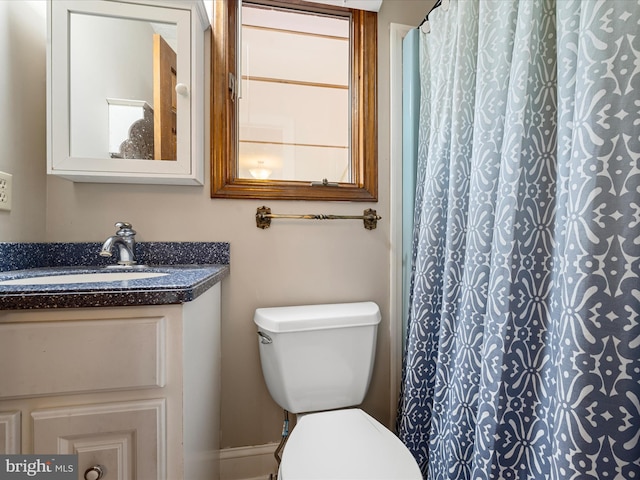 bathroom featuring curtained shower, vanity, and toilet